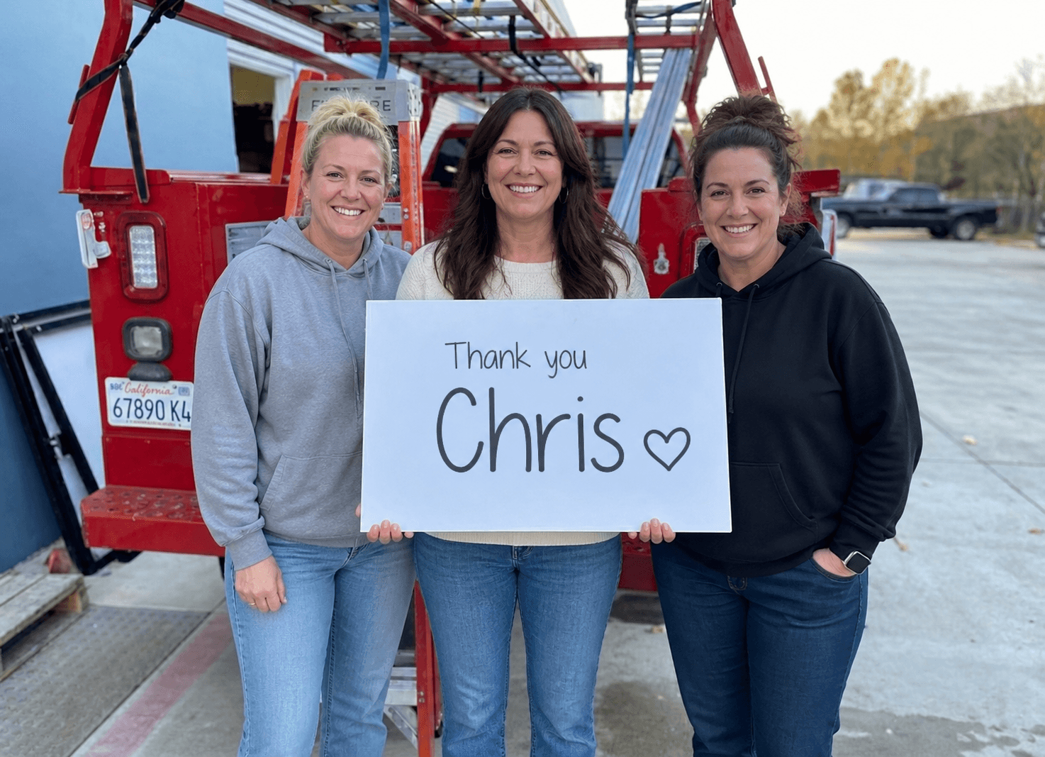 Business owners holding a personalized thank-you sign